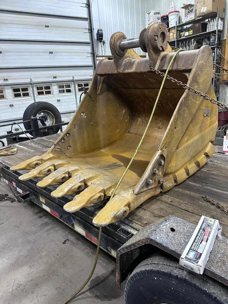 Excavator bucket on flatbed ready for rebuild and repair