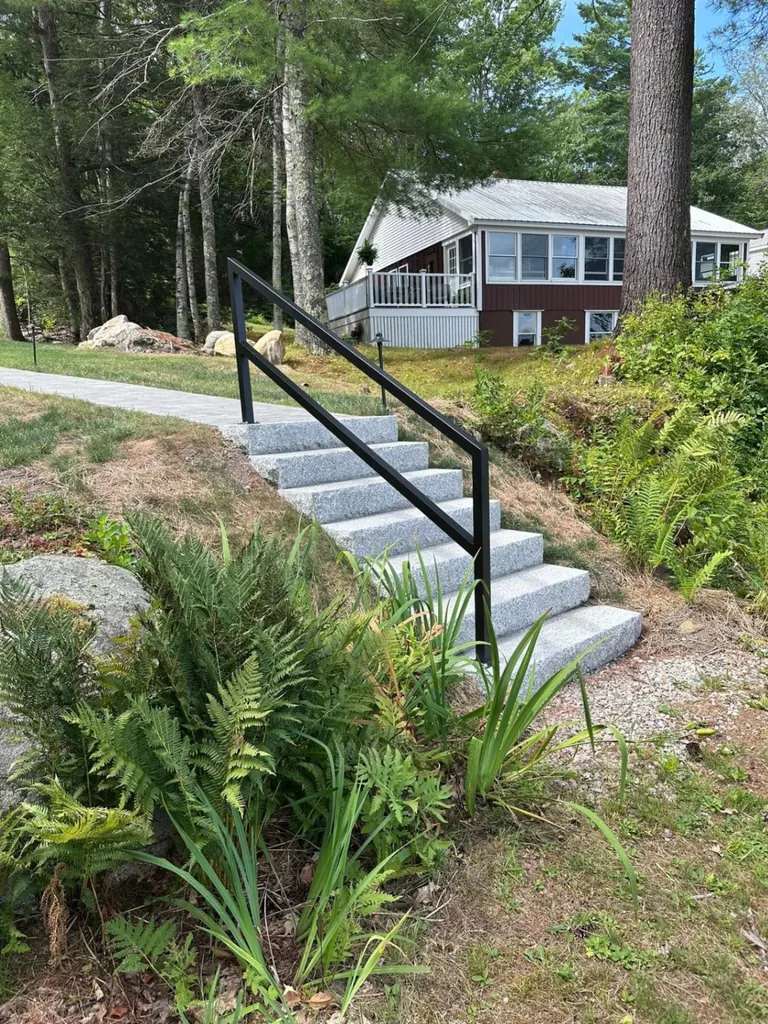 Custom metal handrail installation on granite steps in Maine